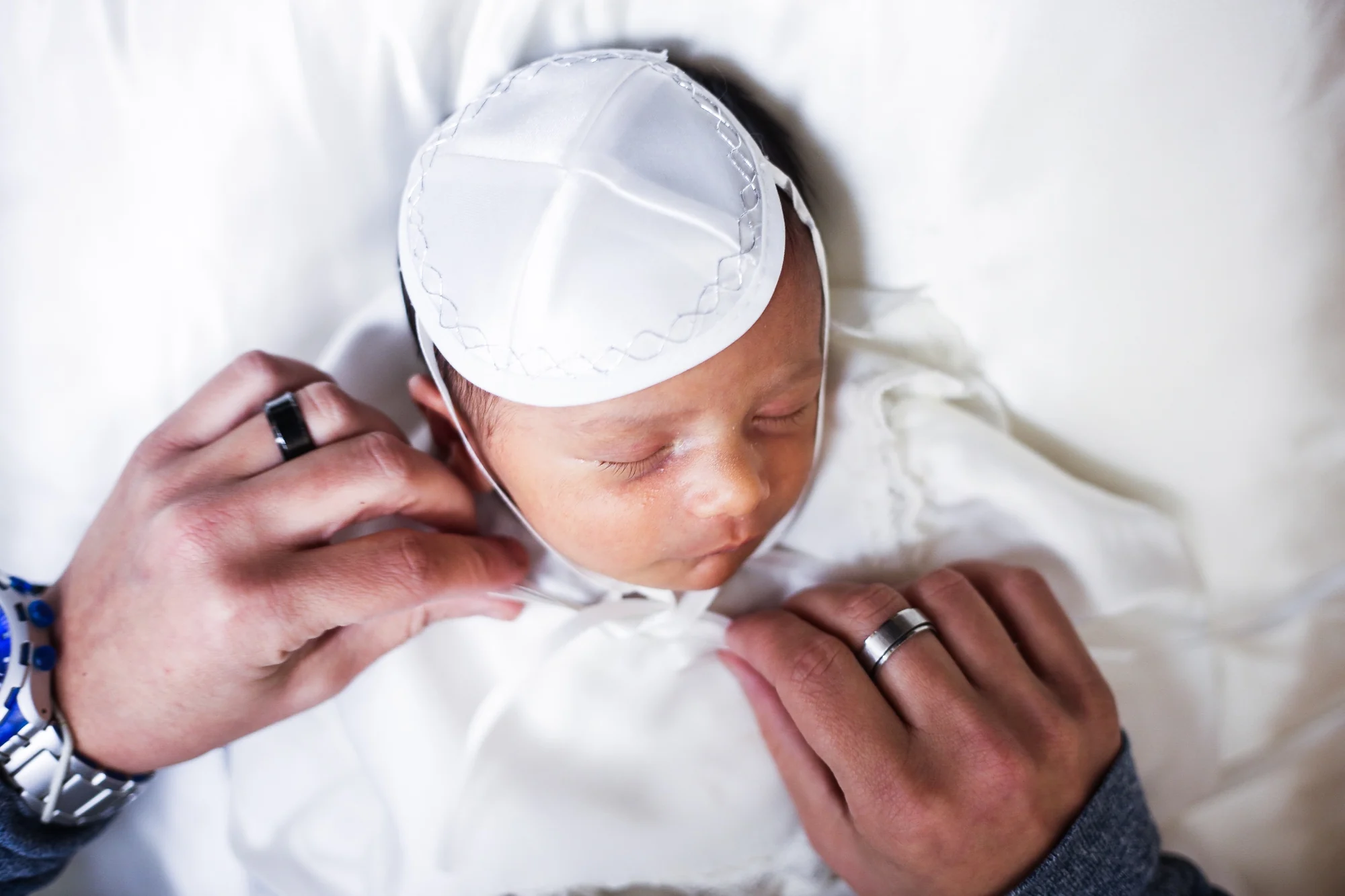 Les mains du père nouent la kippa